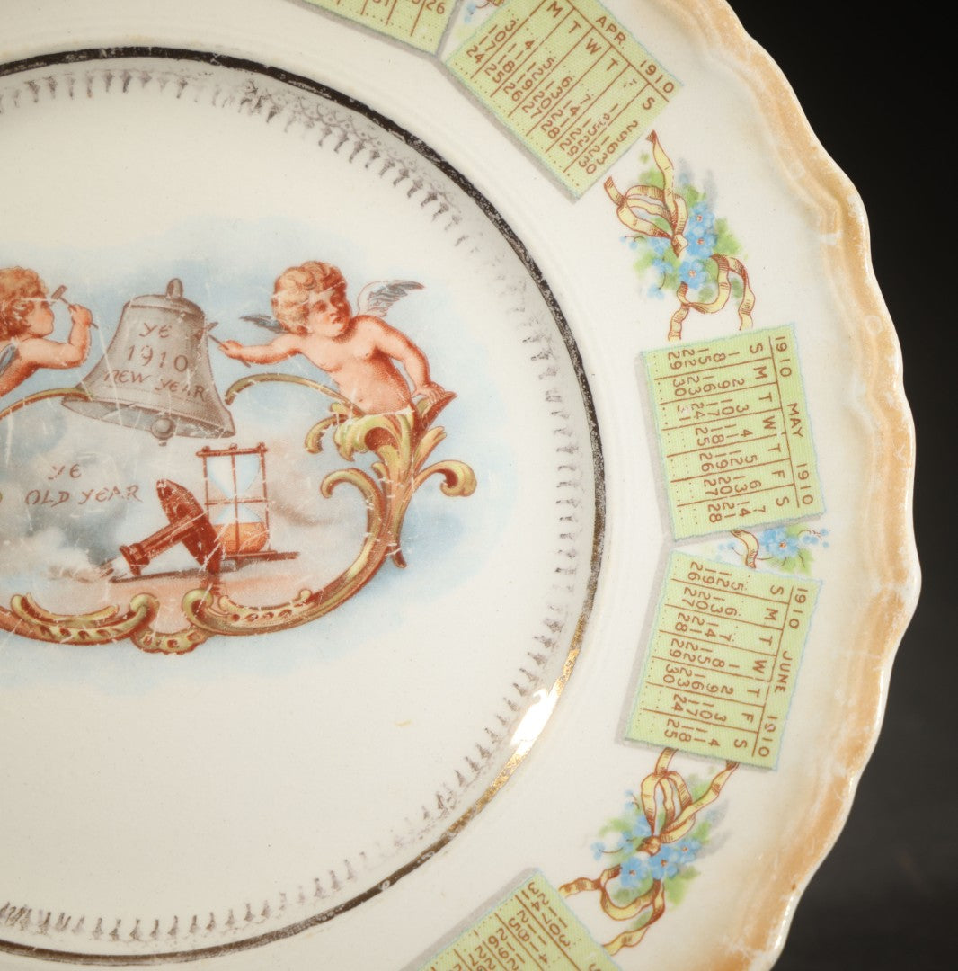 Antique Porcelain 1910 Calendar Plate with Cherubs, New Year Bell, and Hourglass Motif, Note Chip to Lower Center Rim