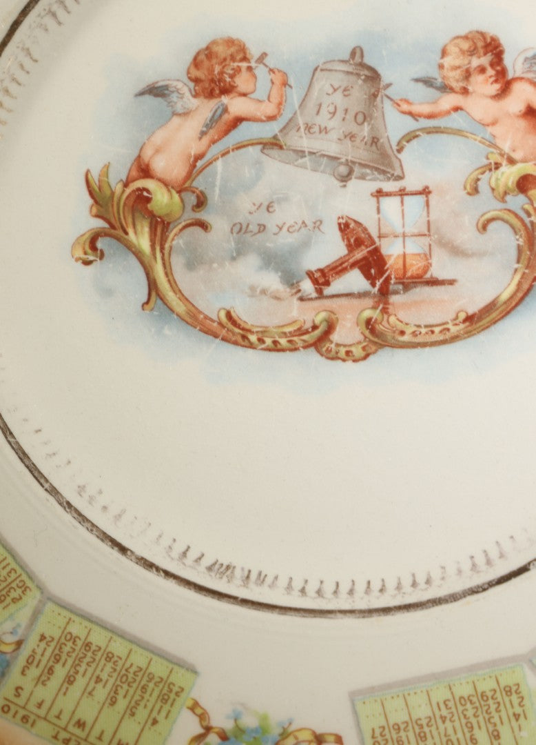 Antique Porcelain 1910 Calendar Plate with Cherubs, New Year Bell, and Hourglass Motif, Note Chip to Lower Center Rim