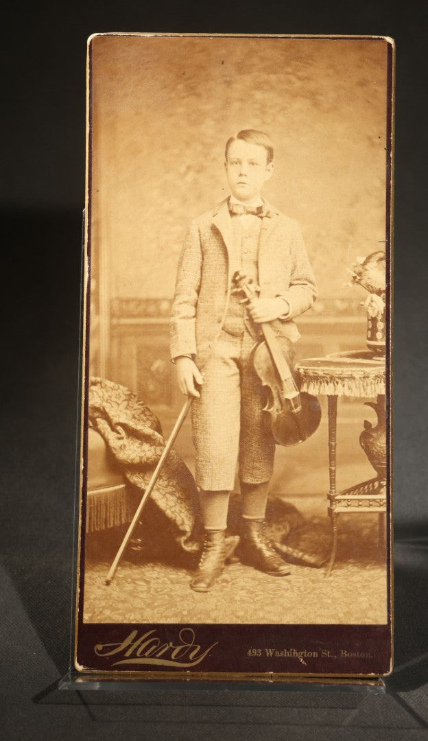 Trio of Antique Board-Mounted Photographs Including a Cabinet Card of a Boy with Violin, by Hardy, Boston, a Horse-Drawn Carriage Party by J. P. Haseltine, Lancaster, New Hampshire, and a Man Posed with Cannons, by Hollis Studio, Boston