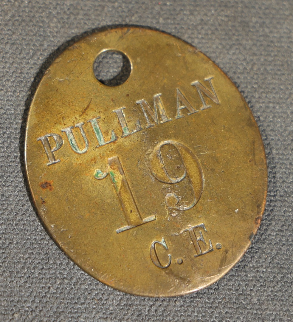 Grouping of four Vintage Railway Employee Badges and Tags including Walkway Over the Hudson Cantilever Bridge Pin, Pullman 19 C.E. Brass Tag, Baldwin A-3107 Special Photo emplopye ID badge, and Brakeman Metal Badge