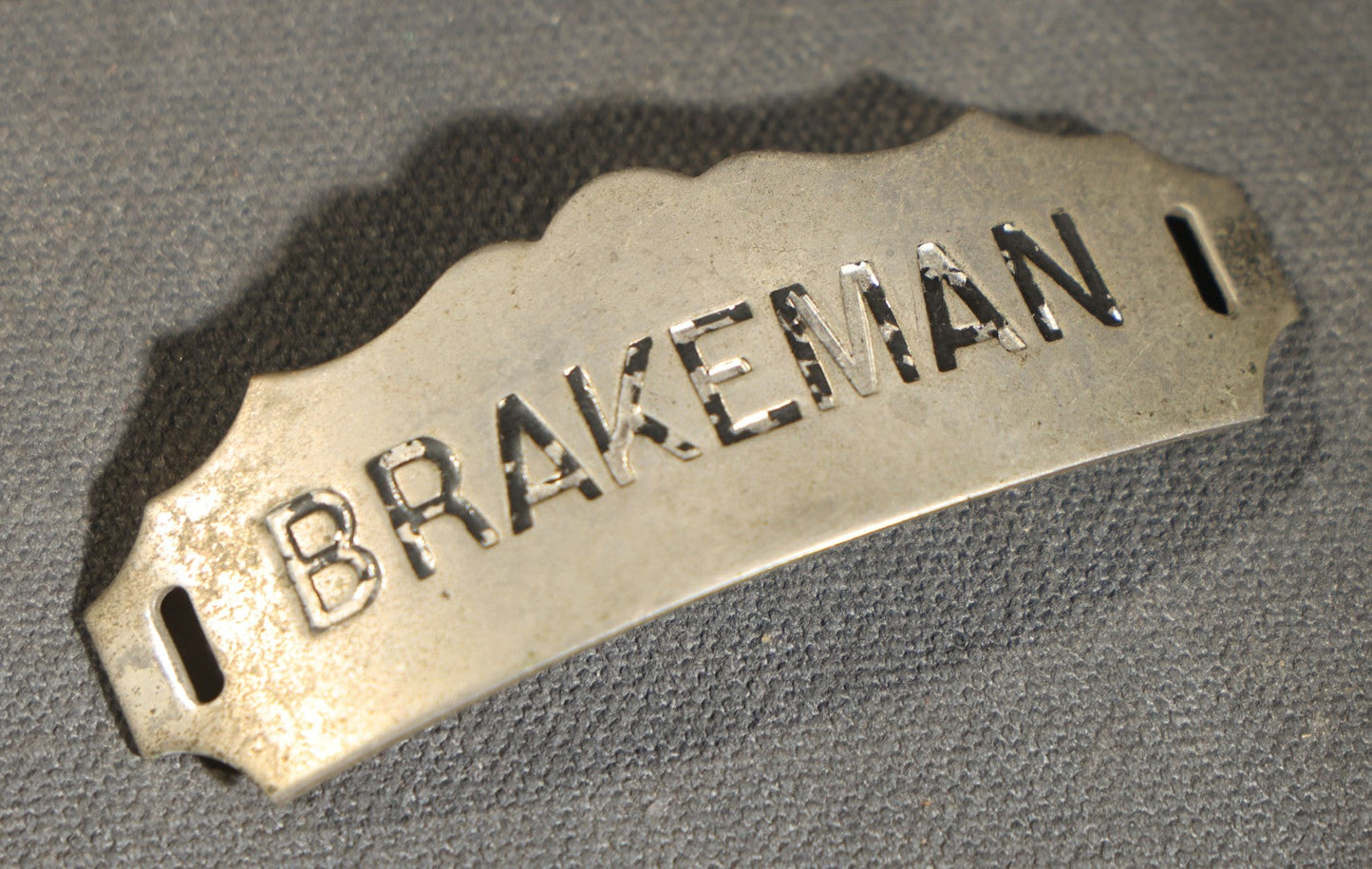 Grouping of four Vintage Railway Employee Badges and Tags including Walkway Over the Hudson Cantilever Bridge Pin, Pullman 19 C.E. Brass Tag, Baldwin A-3107 Special Photo emplopye ID badge, and Brakeman Metal Badge