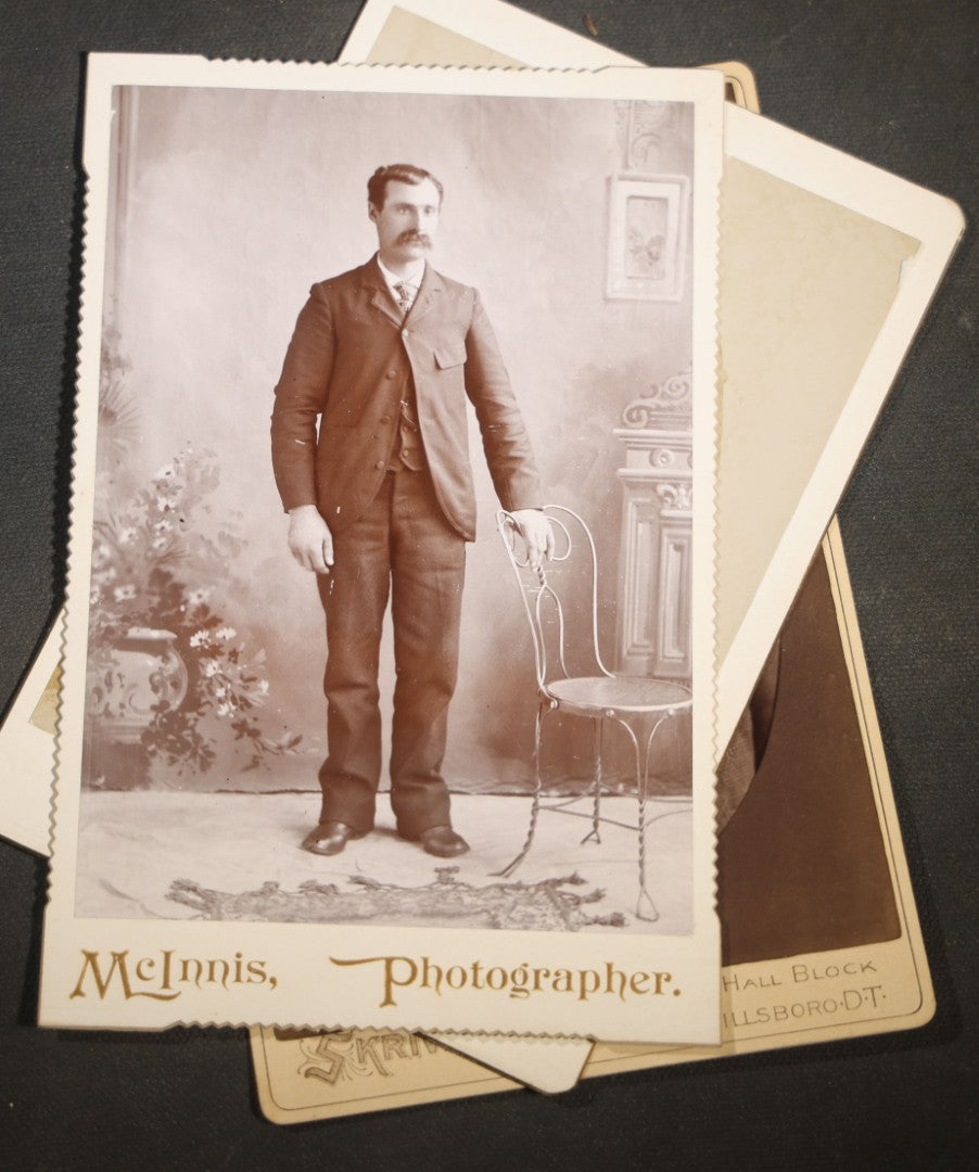Grouping of Nine Antique Cabinet Card Photographs of Men including Examples by McInnis, Skrivseth, and Flaten