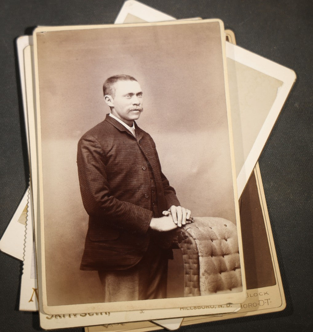 Grouping of Nine Antique Cabinet Card Photographs of Men including Examples by McInnis, Skrivseth, and Flaten