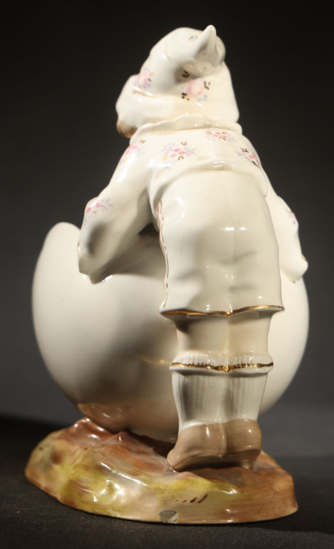Antique Porcelain Figurine of Child in Stocking Cap Looking into Large Egg, Manufactured by Gebruder Heubach, Lichten, Germany, Note Chip