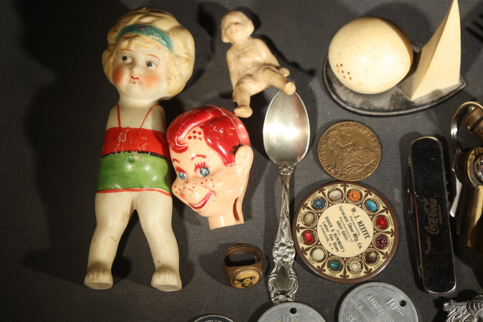 Vintage Junk Drawer Lot Including Bisque Doll, Howdy Doody Head Political Campaign Pins, Advertising Pocket Mirror, Tokens, Keys, and Silverplate Flatware