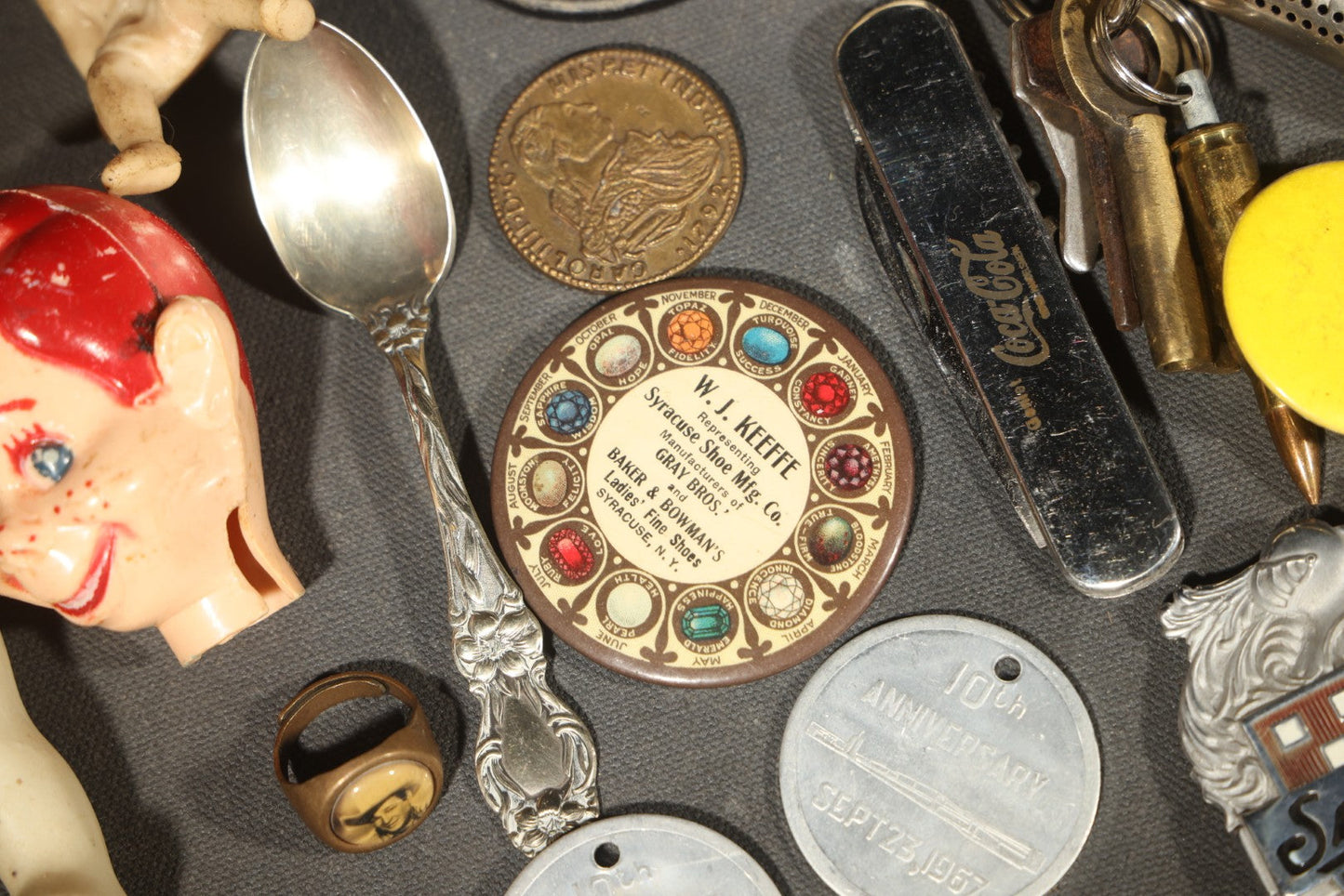 Vintage Junk Drawer Lot Including Bisque Doll, Howdy Doody Head Political Campaign Pins, Advertising Pocket Mirror, Tokens, Keys, and Silverplate Flatware