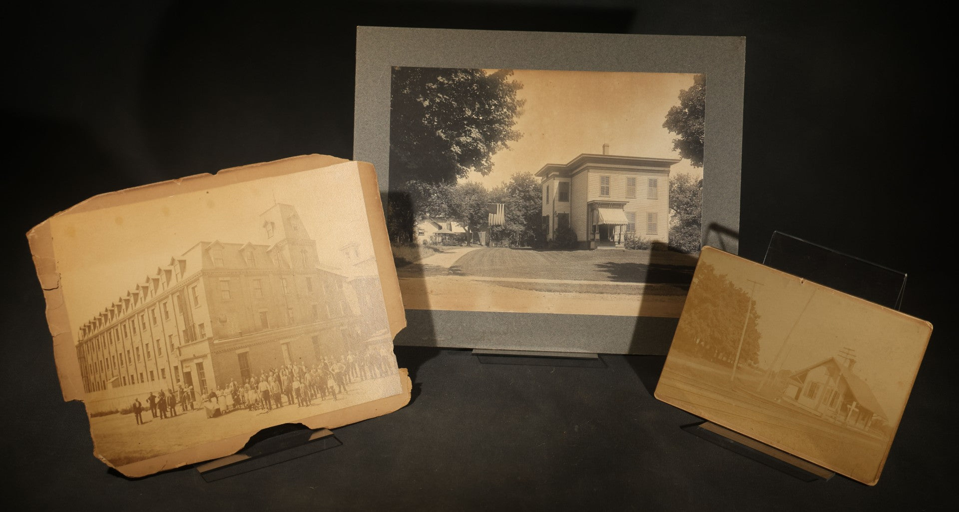 Trio of Vintage Board-Mounted Photographs Including Two-Story House with American Flags, Multi-Story Industrial Building with Gathered Crowd and High Wheel Bicycle, and Small Railroad Depot