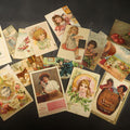 Lot 074 - Grouping of 15 Antique Trade Cards and Postcards Including Victorian Children, Greetings, Floral Designs, and Advertising Cards