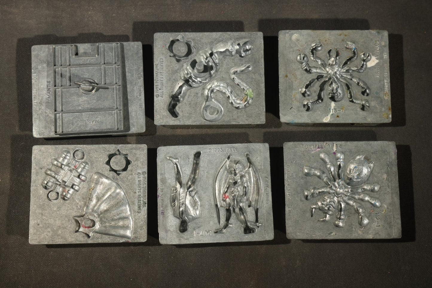 Grouping of 47 Vintage Creepy Crawler Metal Molds including Spiders, Skulls, Insects, and Monsters, Mostly Copyright 1994 by Toymax, with Purple Plastic Toymax Carrying Case