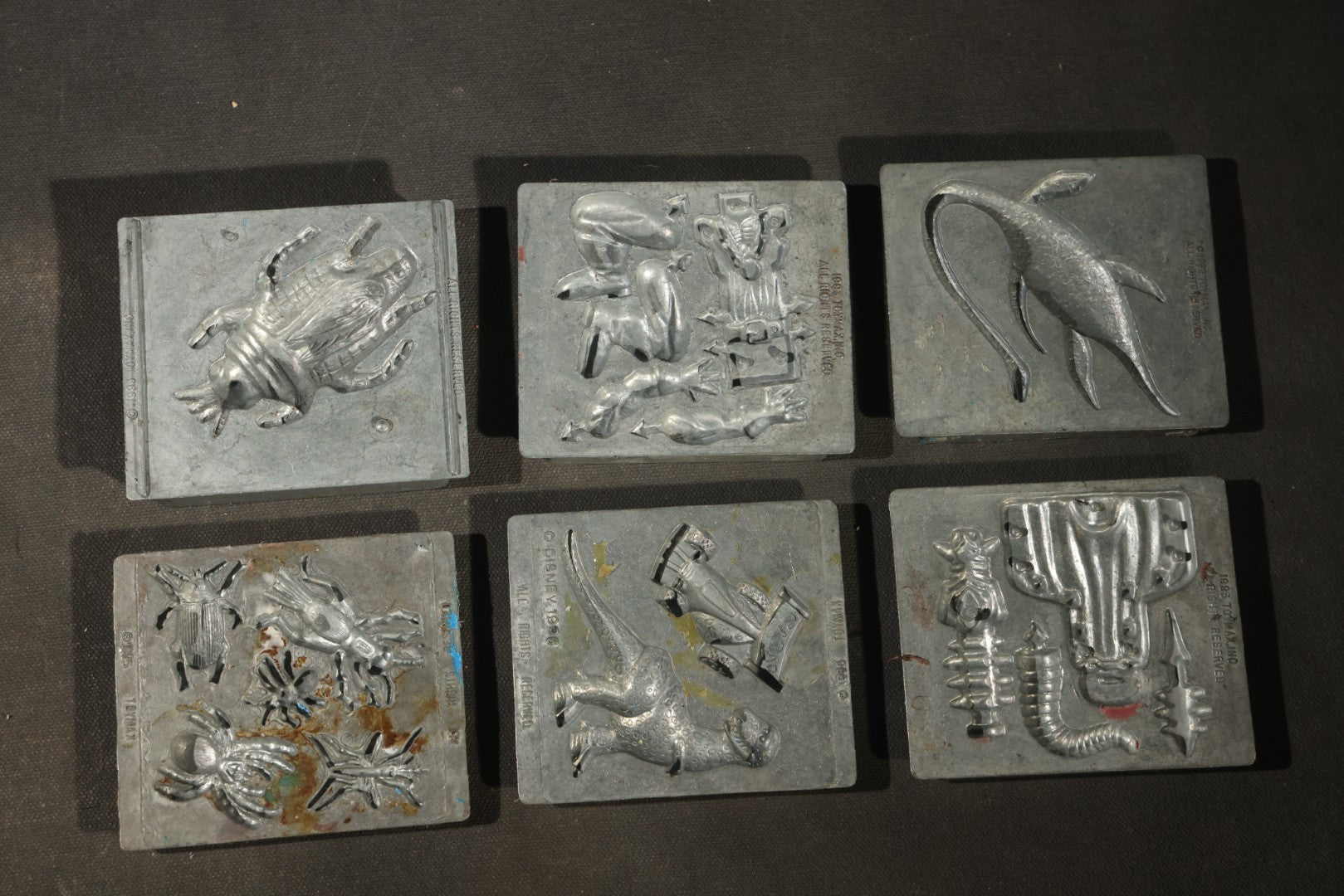 Grouping of 47 Vintage Creepy Crawler Metal Molds including Spiders, Skulls, Insects, and Monsters, Mostly Copyright 1994 by Toymax, with Purple Plastic Toymax Carrying Case