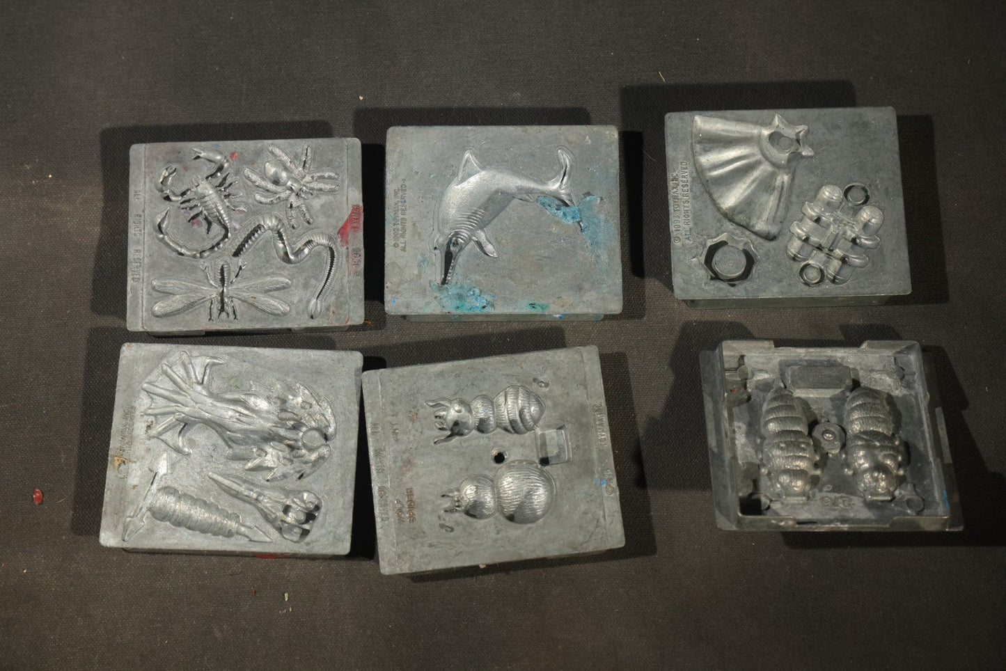 Grouping of 47 Vintage Creepy Crawler Metal Molds including Spiders, Skulls, Insects, and Monsters, Mostly Copyright 1994 by Toymax, with Purple Plastic Toymax Carrying Case