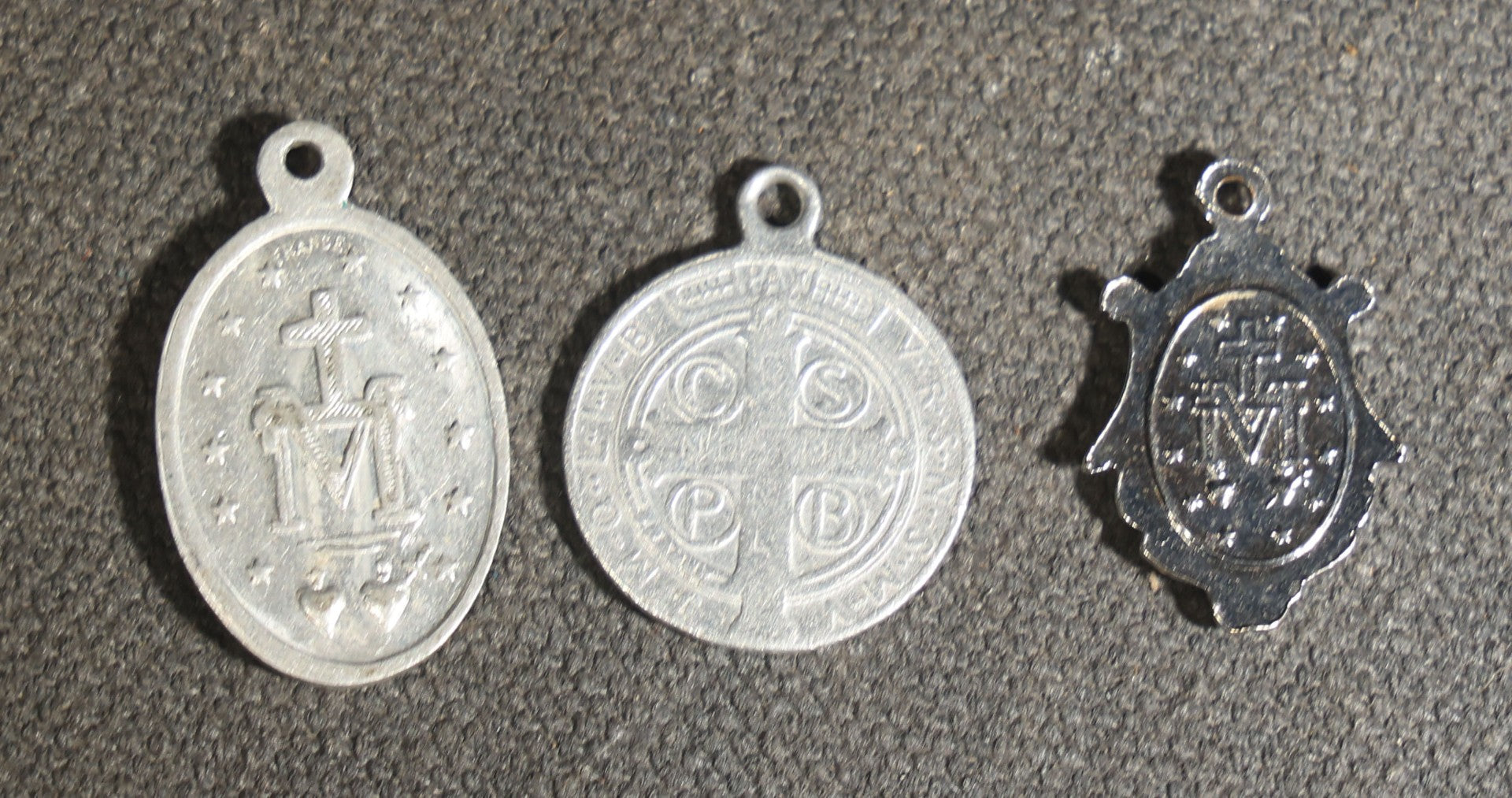 Grouping of 11 Antique and Vintage Religious Medals including Four Sterling Silver Examples with Various Saints, Miraculous Medal, Sacred Heart, and Crucifix Motifs