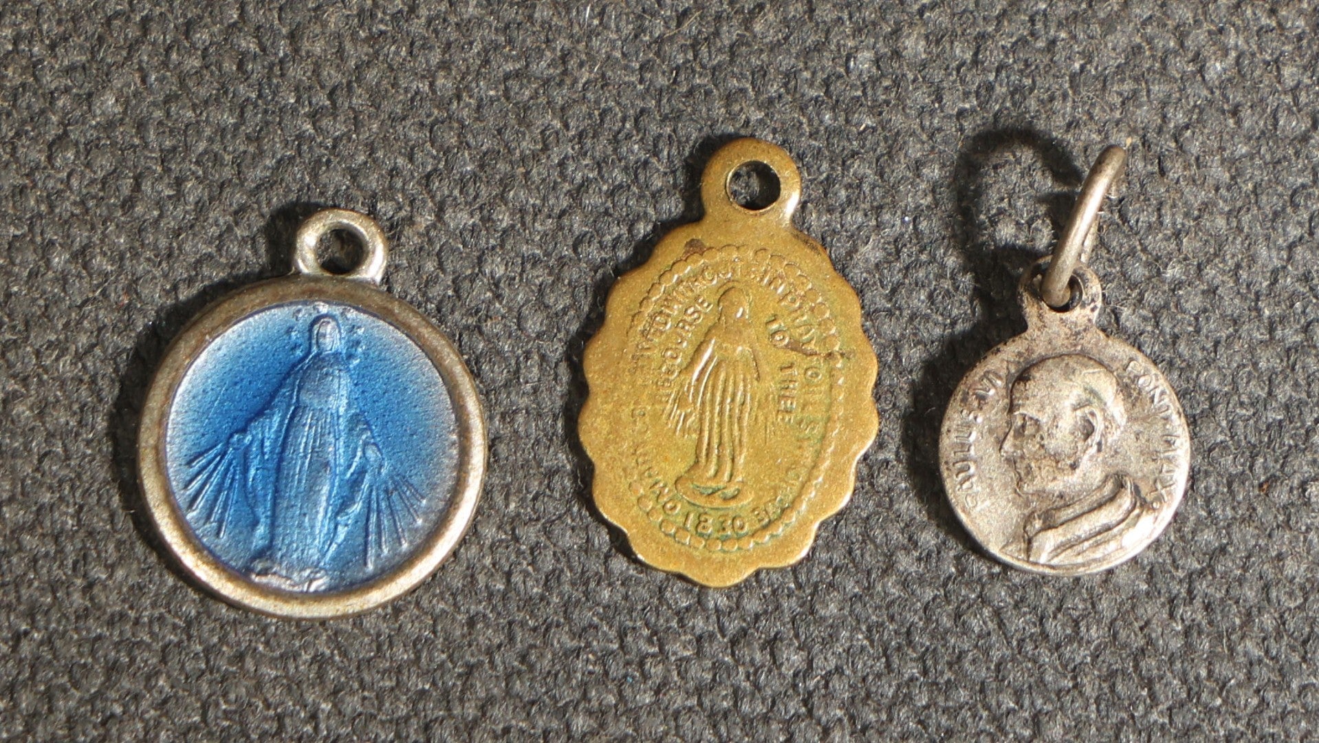 Grouping of 11 Antique and Vintage Religious Medals including Four Sterling Silver Examples with Various Saints, Miraculous Medal, Sacred Heart, and Crucifix Motifs