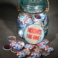 Lot 088 - Grouping of Vintage Political Campaign Buttons and Pins Including Nixon/Agnew, Johnson, Jimmy Carter Peanut Pins, and Lenticular "Nixon's the One!" Button in Wire Bail Glass Storage Jar