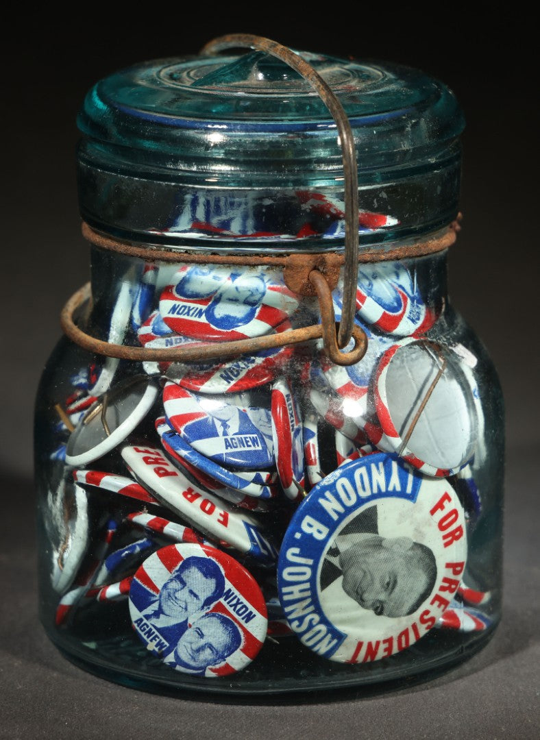 Grouping of Vintage Political Campaign Buttons and Pins including Nixon/Agnew, Johnson, Jimmy Carter Peanut Pins, and Lenticular "Nixon's the One!" Button in Wire Bail Glass Storage Jar