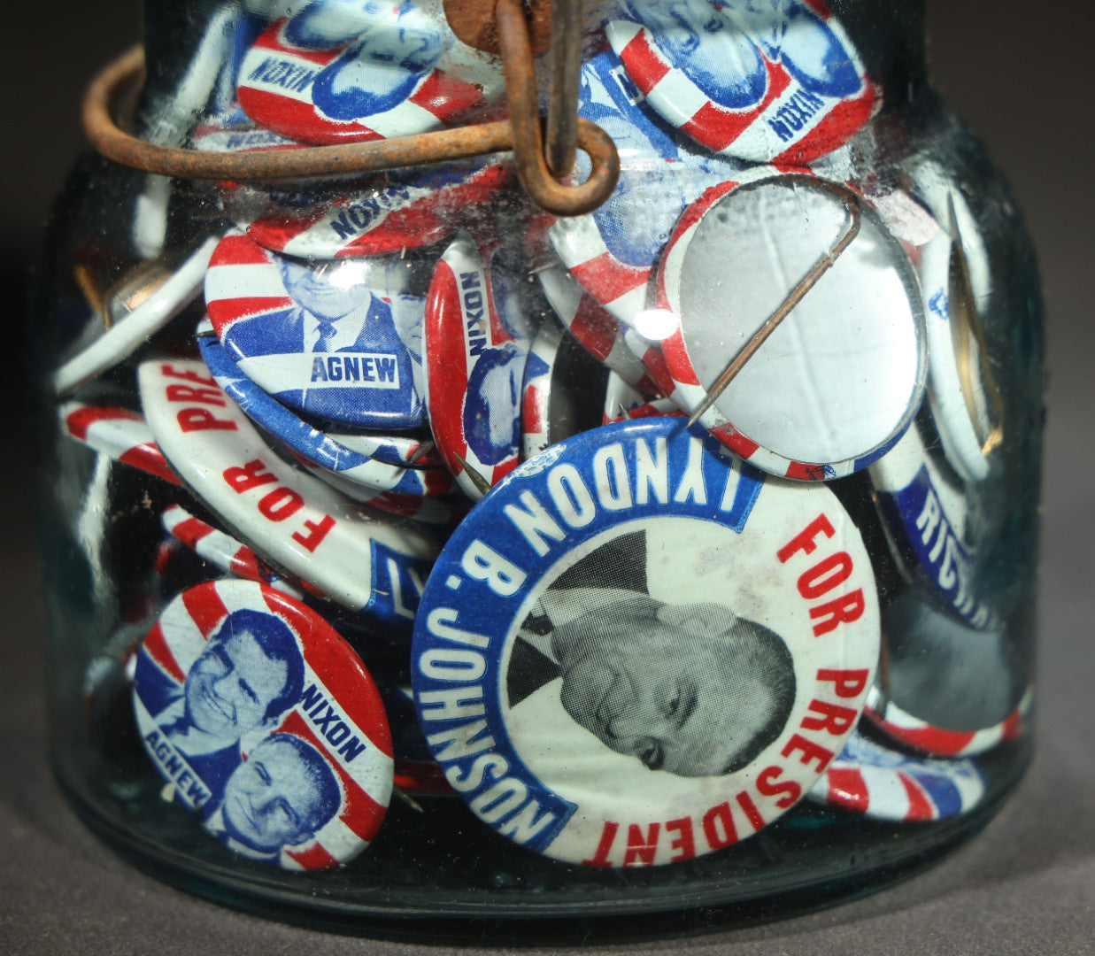 Grouping of Vintage Political Campaign Buttons and Pins including Nixon/Agnew, Johnson, Jimmy Carter Peanut Pins, and Lenticular "Nixon's the One!" Button in Wire Bail Glass Storage Jar