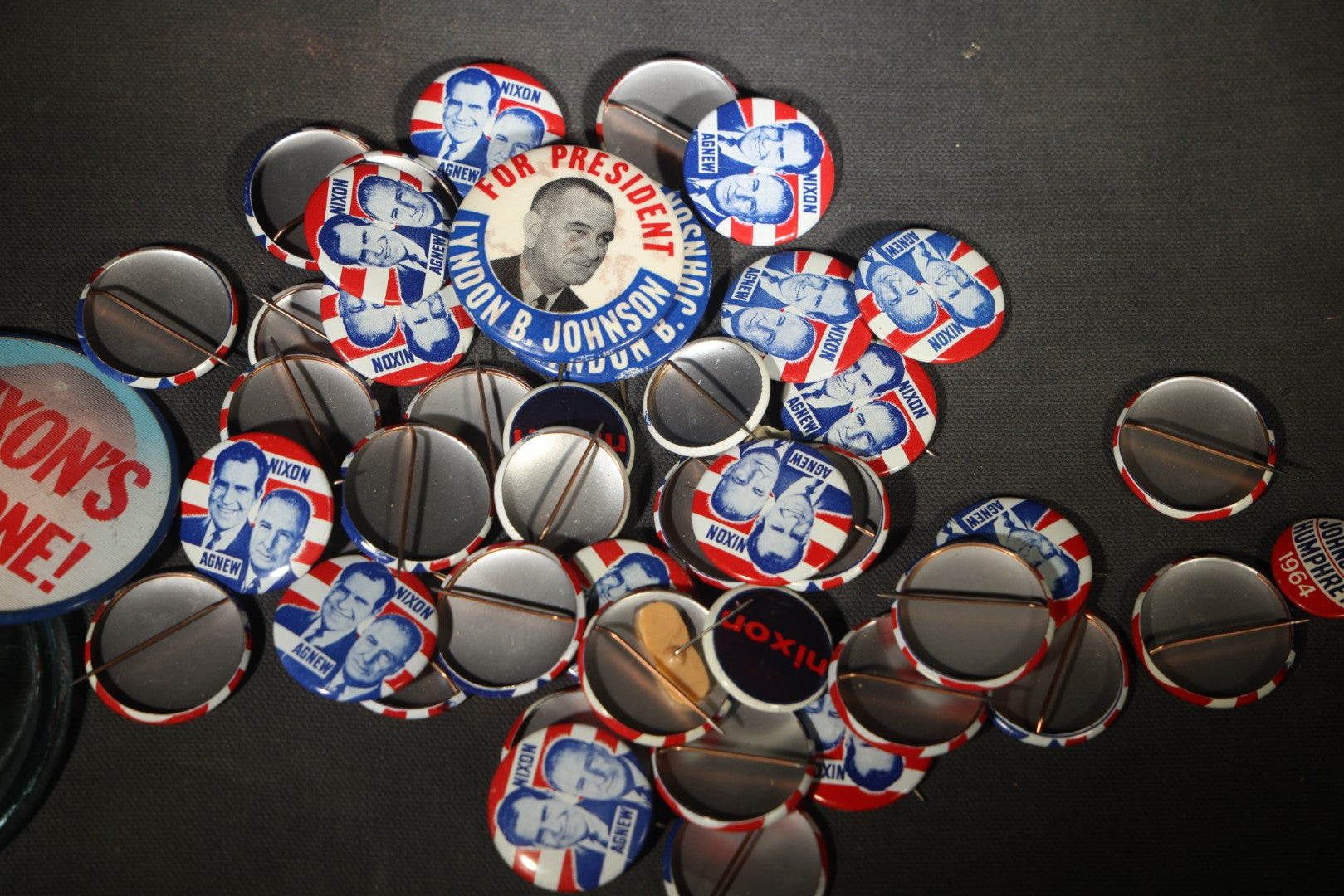 Grouping of Vintage Political Campaign Buttons and Pins including Nixon/Agnew, Johnson, Jimmy Carter Peanut Pins, and Lenticular "Nixon's the One!" Button in Wire Bail Glass Storage Jar
