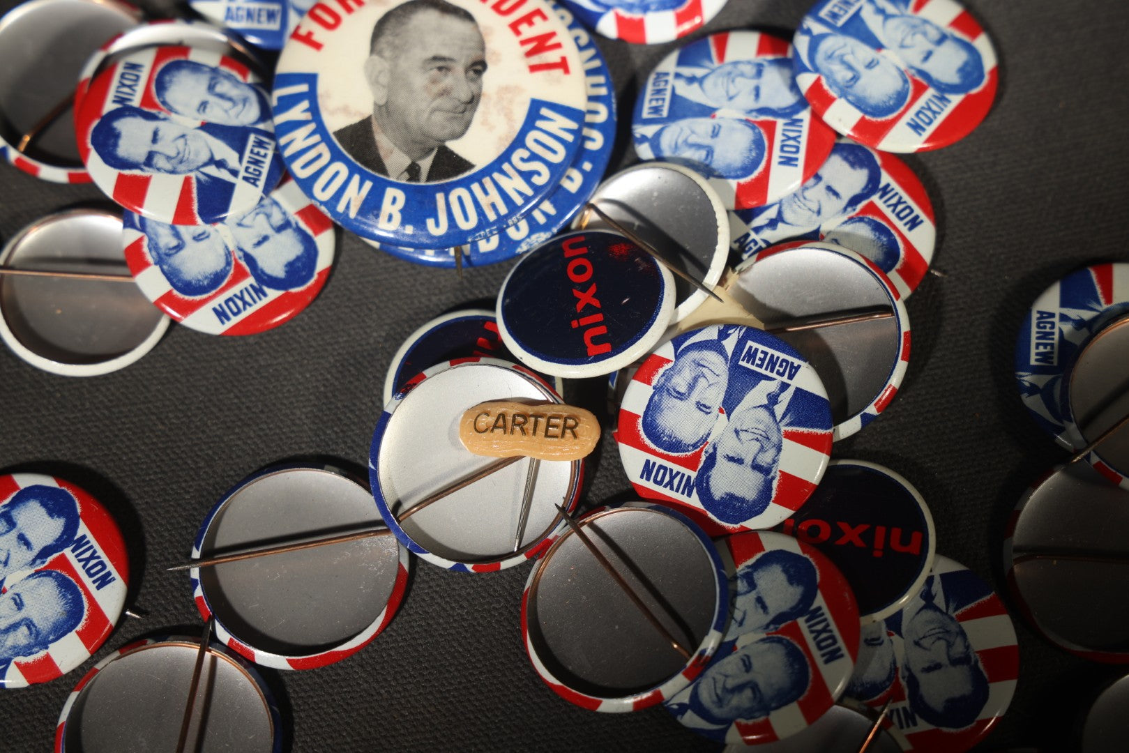 Grouping of Vintage Political Campaign Buttons and Pins including Nixon/Agnew, Johnson, Jimmy Carter Peanut Pins, and Lenticular "Nixon's the One!" Button in Wire Bail Glass Storage Jar
