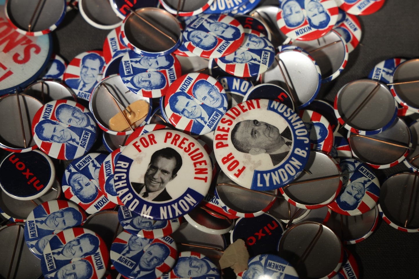 Grouping of Vintage Political Campaign Buttons and Pins including Nixon/Agnew, Johnson, Jimmy Carter Peanut Pins, and Lenticular "Nixon's the One!" Button in Wire Bail Glass Storage Jar