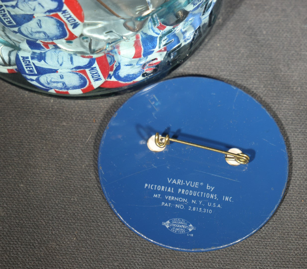 Grouping of Vintage Political Campaign Buttons and Pins including Nixon/Agnew, Johnson, Jimmy Carter Peanut Pins, and Lenticular "Nixon's the One!" Button in Wire Bail Glass Storage Jar