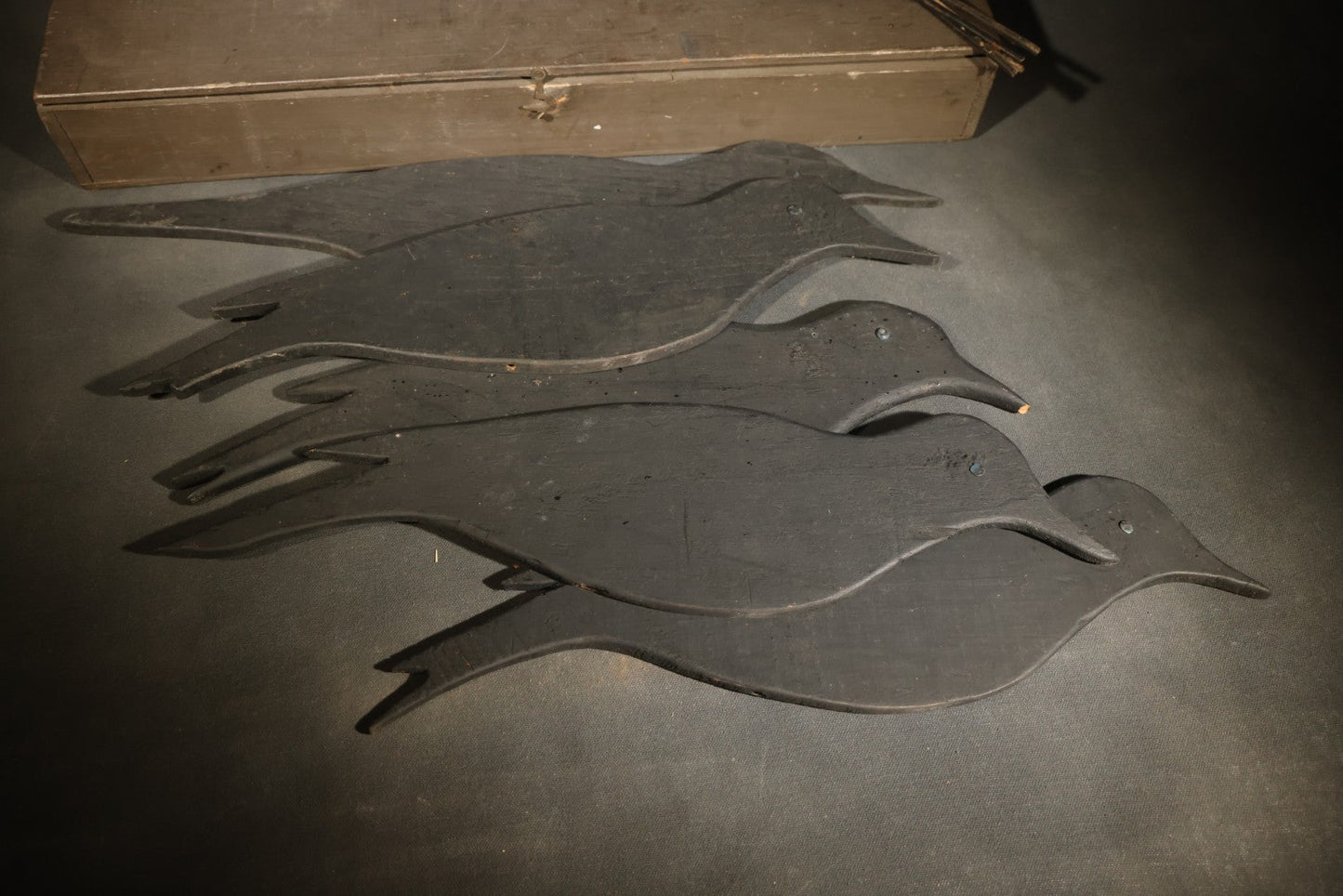 Grouping of Five Antique Black-Painted Flat Crow Silhouette Stick-Up Decoys with Support Poles in Wooden Storage Box
