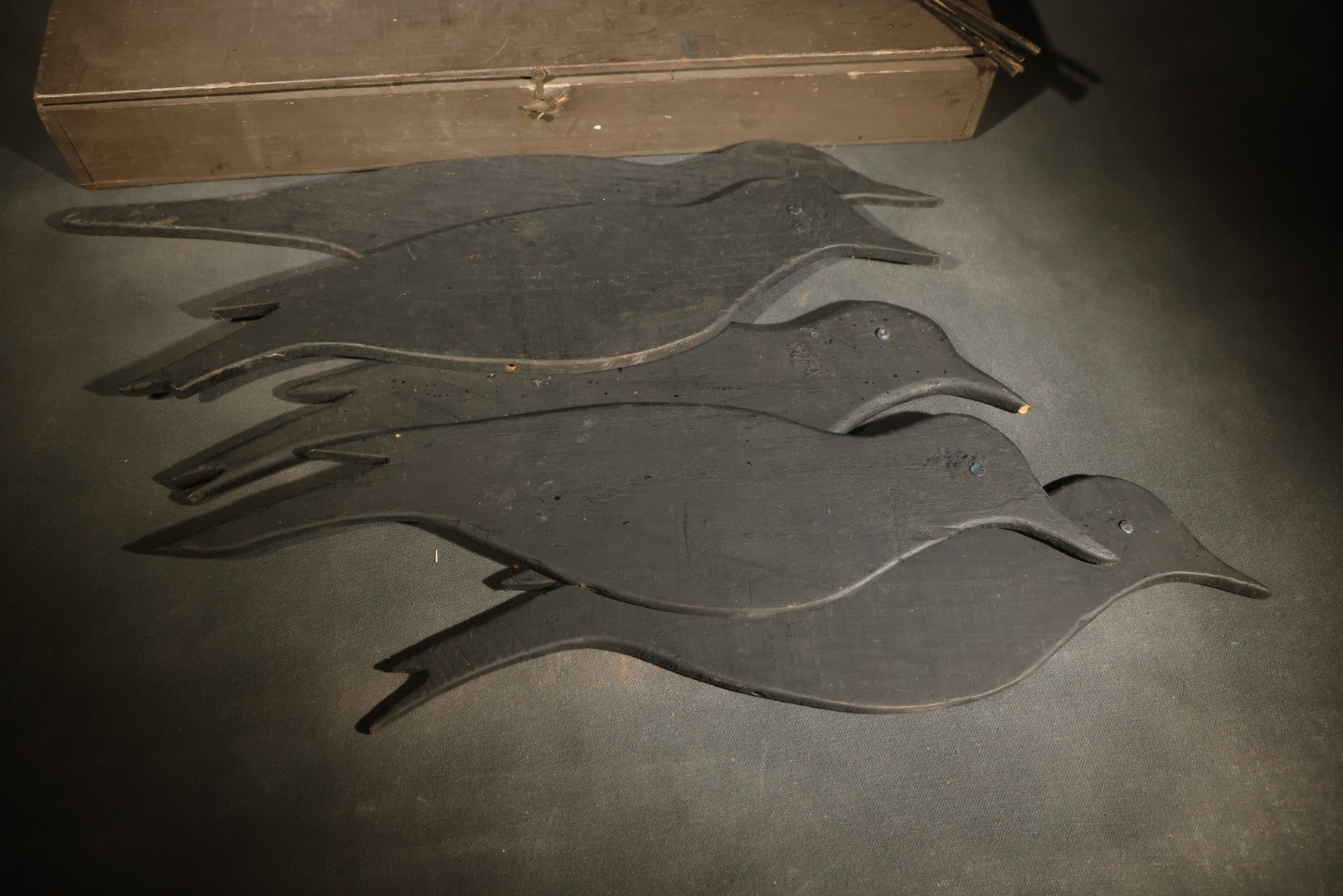 Grouping of Five Antique Black-Painted Flat Crow Silhouette Stick-Up Decoys with Support Poles in Wooden Storage Box