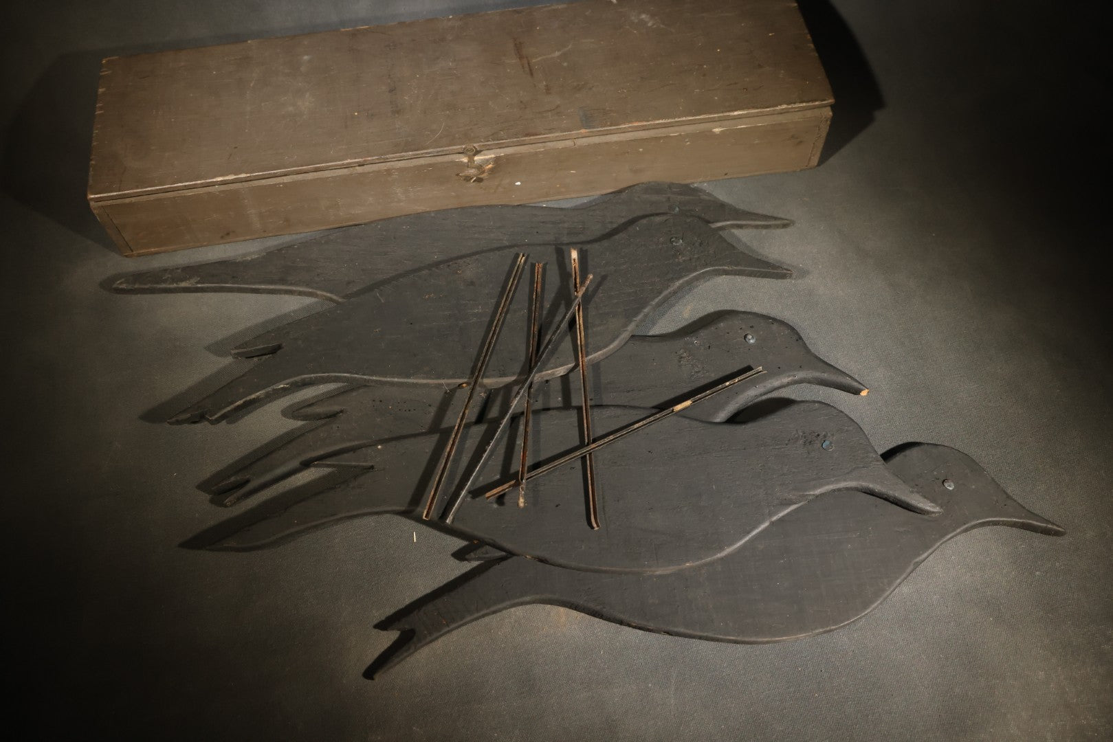 Grouping of Five Antique Black-Painted Flat Crow Silhouette Stick-Up Decoys with Support Poles in Wooden Storage Box