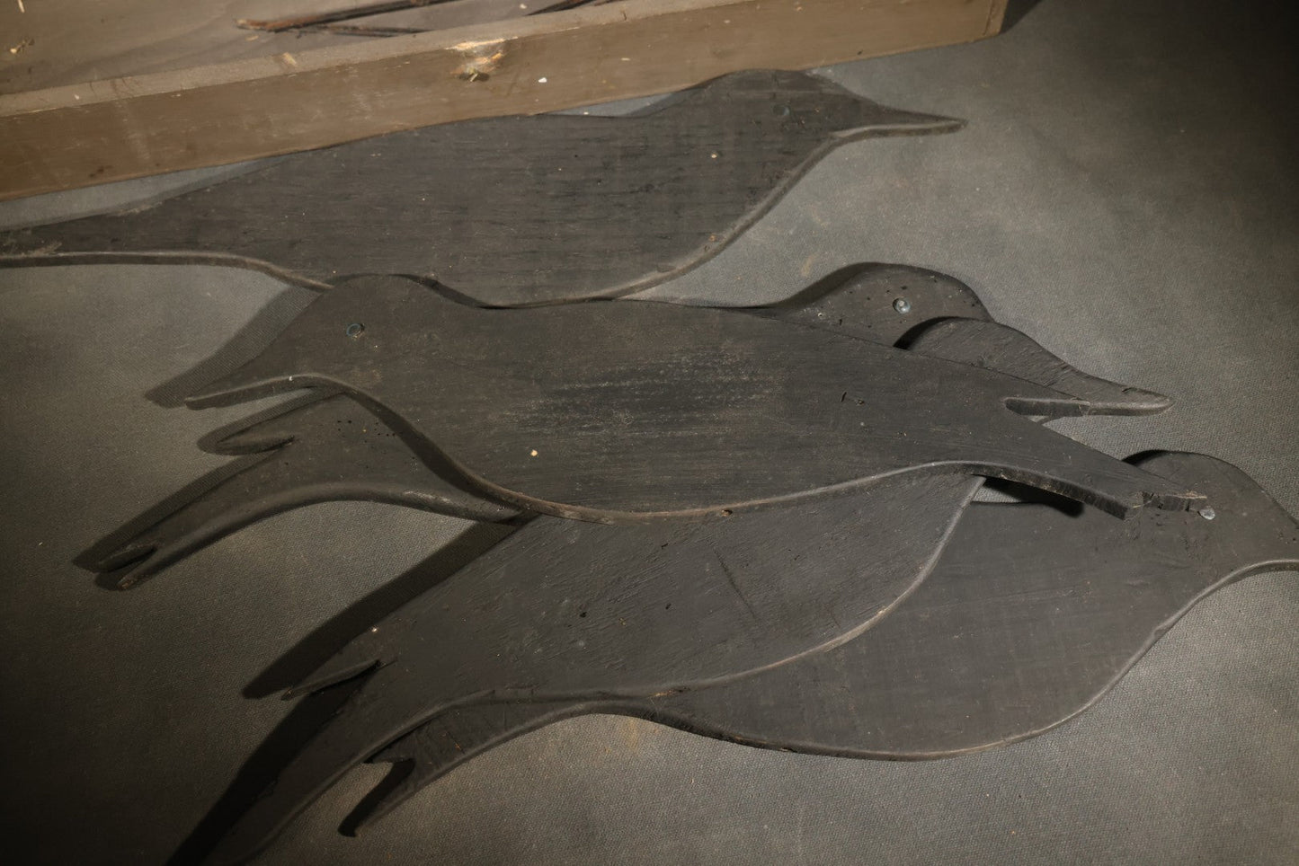 Grouping of Five Antique Black-Painted Flat Crow Silhouette Stick-Up Decoys with Support Poles in Wooden Storage Box