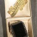 Lot 054 - Antique Black Glass Mourning Brooch with Twisted Rope Border in L. Schmidt Diamond Merchant & Optician Jeweler's Box, Braddock, Pennsylvania