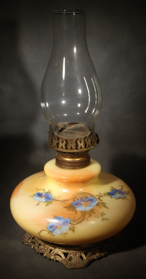 Antique Hand-Painted Glass Oil Lamp with Blue Floral Decoration, Brass Burner, and Ornate Cast Metal Base