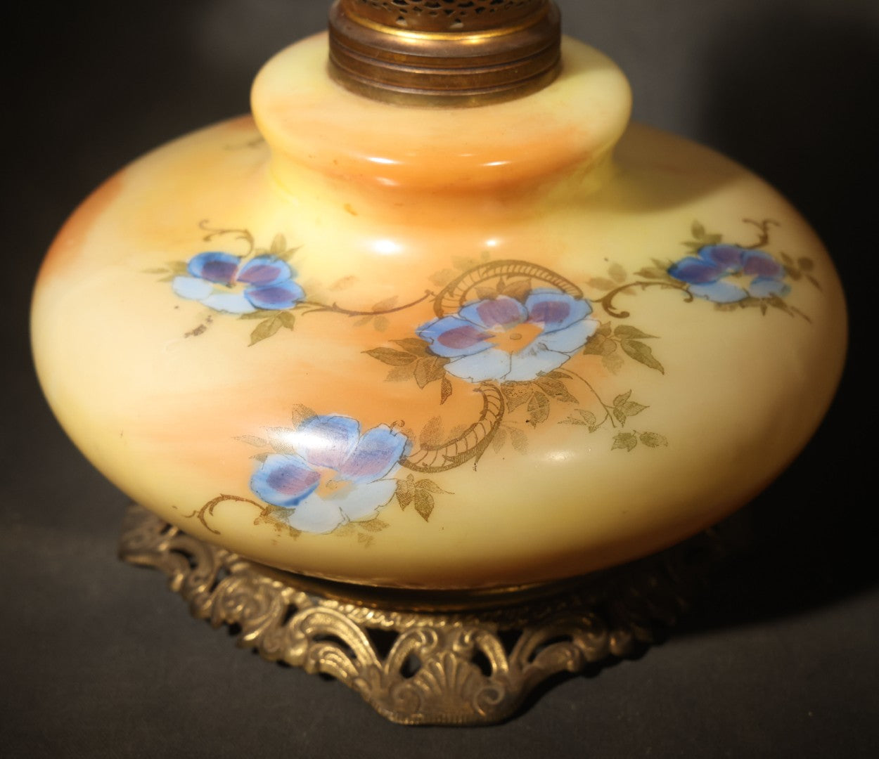 Antique Hand-Painted Glass Oil Lamp with Blue Floral Decoration, Brass Burner, and Ornate Cast Metal Base
