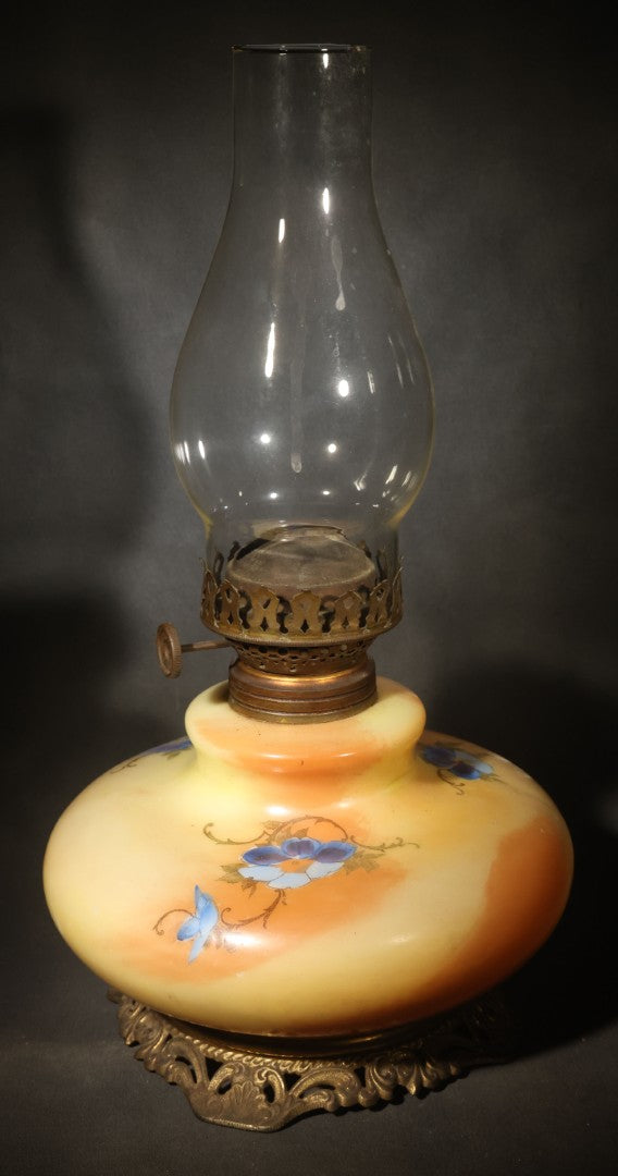 Antique Hand-Painted Glass Oil Lamp with Blue Floral Decoration, Brass Burner, and Ornate Cast Metal Base