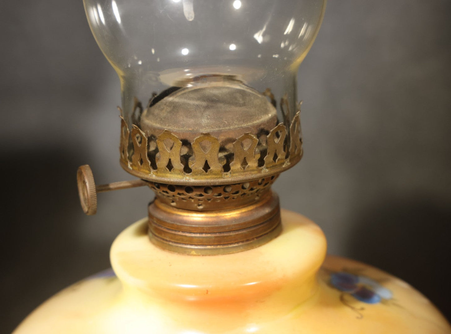 Antique Hand-Painted Glass Oil Lamp with Blue Floral Decoration, Brass Burner, and Ornate Cast Metal Base