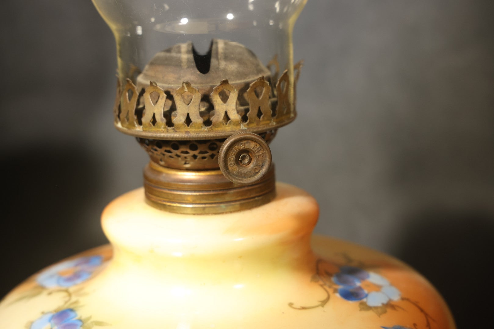 Antique Hand-Painted Glass Oil Lamp with Blue Floral Decoration, Brass Burner, and Ornate Cast Metal Base