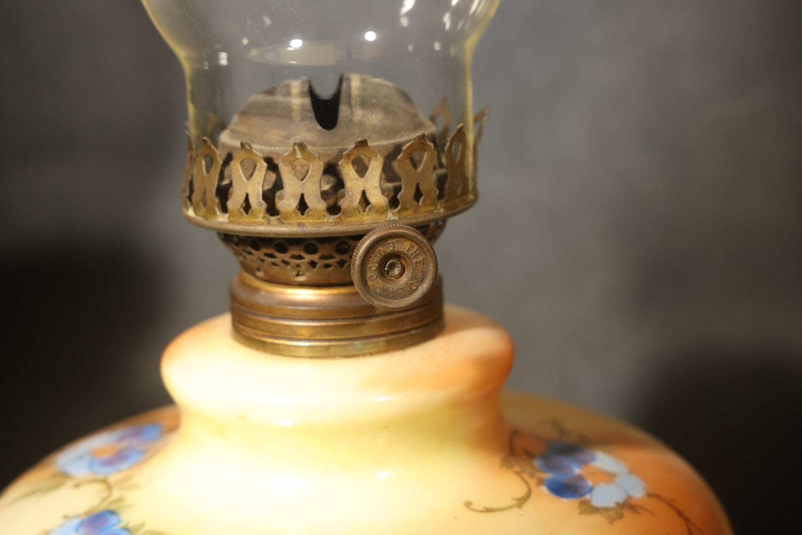 Antique Hand-Painted Glass Oil Lamp with Blue Floral Decoration, Brass Burner, and Ornate Cast Metal Base