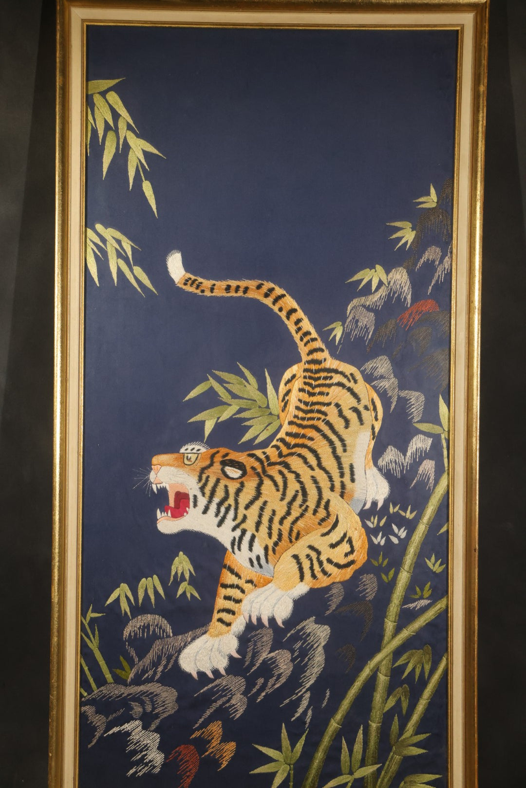 Vintage Framed Japanese Silk Embroidery of a Roaring Tiger Among Bamboo and Rocks on Navy Ground, Inscribed on Verso March 29, 1976