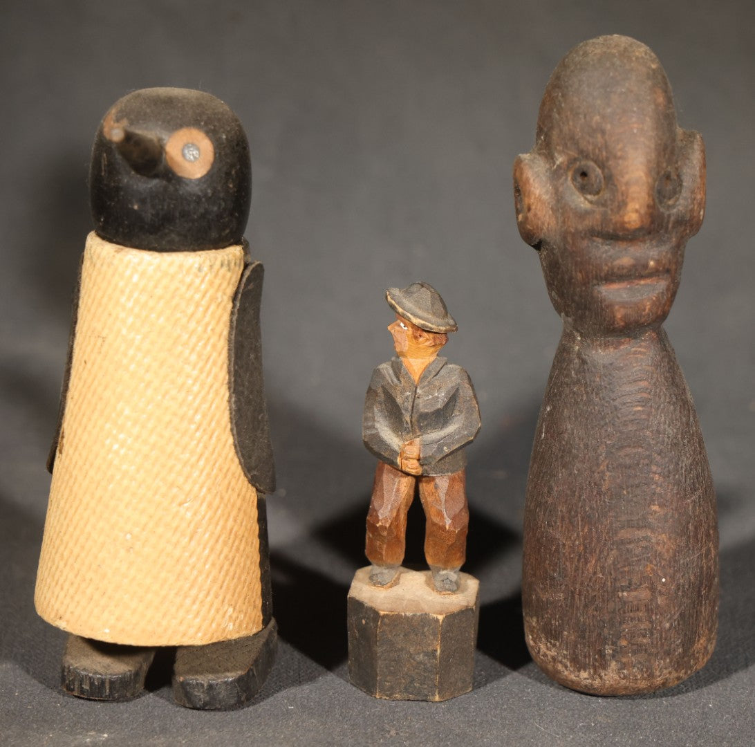 Trio of Antique Carved Wood Figures including a Penguin, a Painted Man in Cap and Jacket, and a Dark-Stained Anthropomorphic Figure