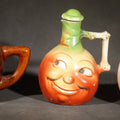 Lot 127 - Trio of Vintage Figural Face Ceramics Including Brown Glazed Smiley Mug, Anthropomorphic Tomato Jug with Lid, and Czechoslovakia Porcelanit Smiling Face Mug