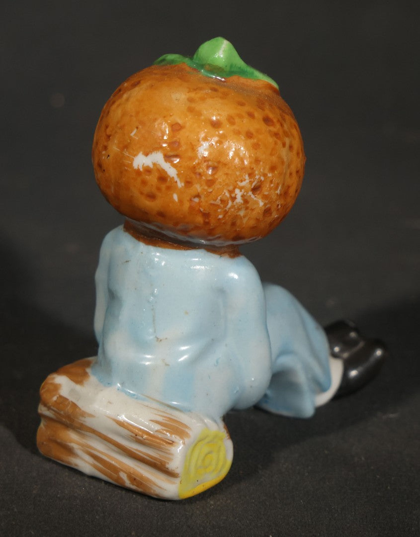 Trio of Vintage Porcelain Figurines including Clown with Violin, Open-Mouth Yawning Baby, and Orange-Head Child on Log