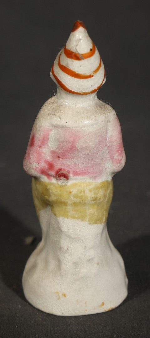Trio of Vintage Porcelain Figurines including Clown with Violin, Open-Mouth Yawning Baby, and Orange-Head Child on Log