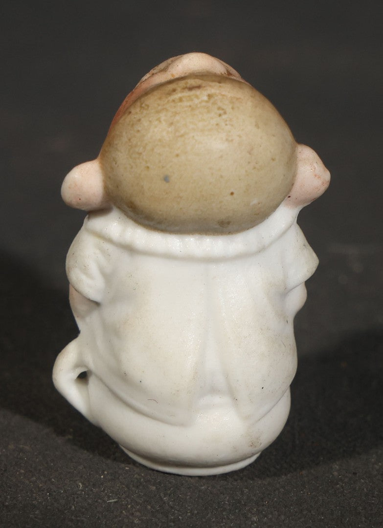Trio of Vintage Porcelain Figurines including Clown with Violin, Open-Mouth Yawning Baby, and Orange-Head Child on Log