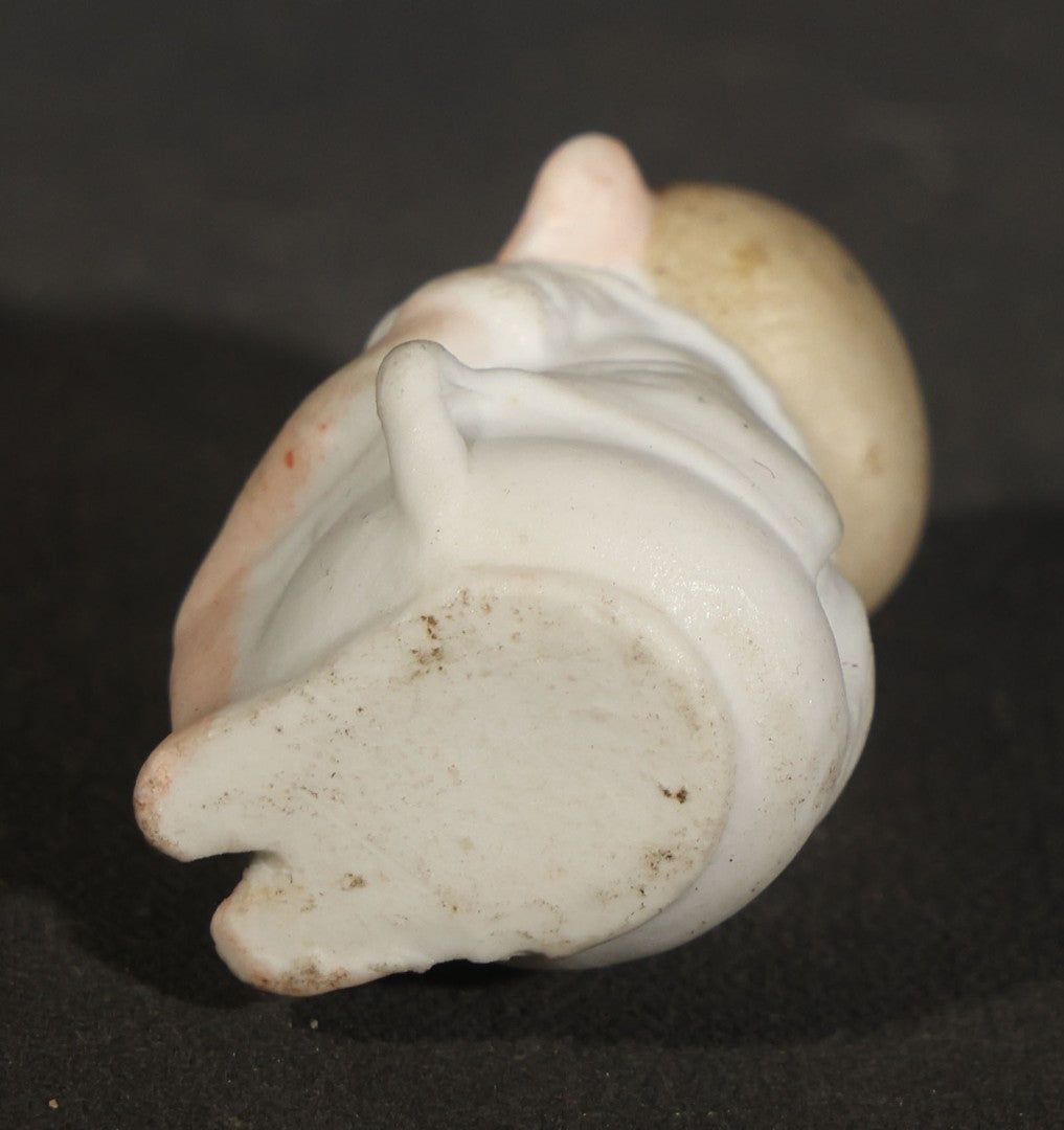 Trio of Vintage Porcelain Figurines including Clown with Violin, Open-Mouth Yawning Baby, and Orange-Head Child on Log