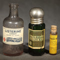 Lot 059 - Trio of Antique Labeled Bottles Including Listerine from Paxson & Rockefeller Co. of Butte, Montana, No. 4711 Eau De Cologne Smelling Salts by Mulhens & Kropff, and Whitman Toothache Gum