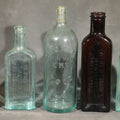 Lot 064 - Grouping of Five Antique Embossed Glass Bottles Including Moxie Nerve Food, Father John's Medicine, and Hood's Sarsaparilla