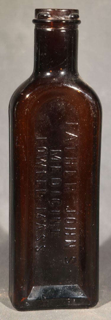Grouping of Five Antique Embossed Glass Bottles including Moxie Nerve Food, Father John's Medicine, and Hood's Sarsaparilla