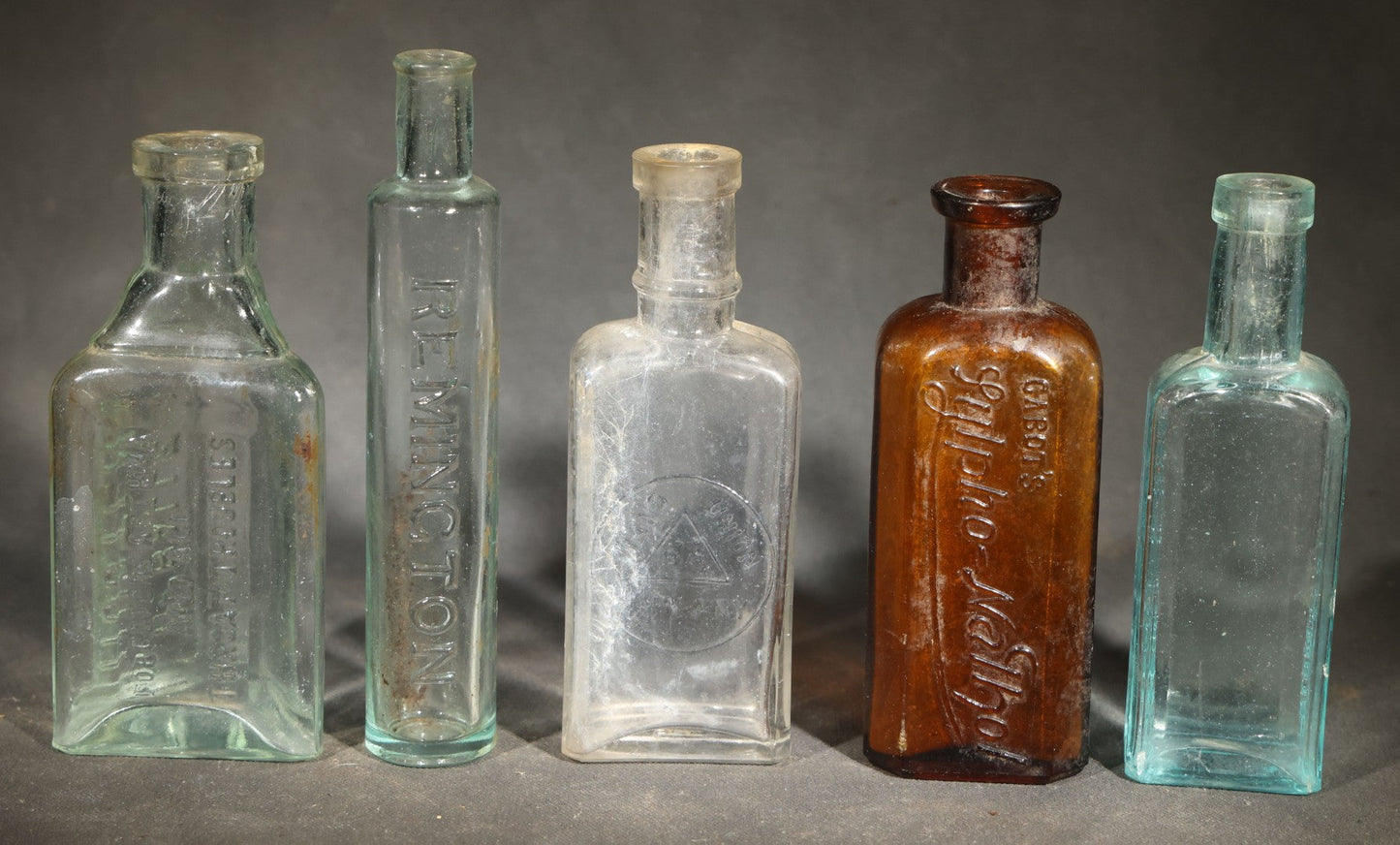 Grouping of Five Antique Embossed Glass Bottles including Remington and Gibbs Sulpho-Napthol