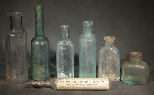 Grouping of Seven Antique Glass Bottles including Ethyl Chloride U.S.P. Anaesthesia Tube and Embossed Pharmaceutical Bottles