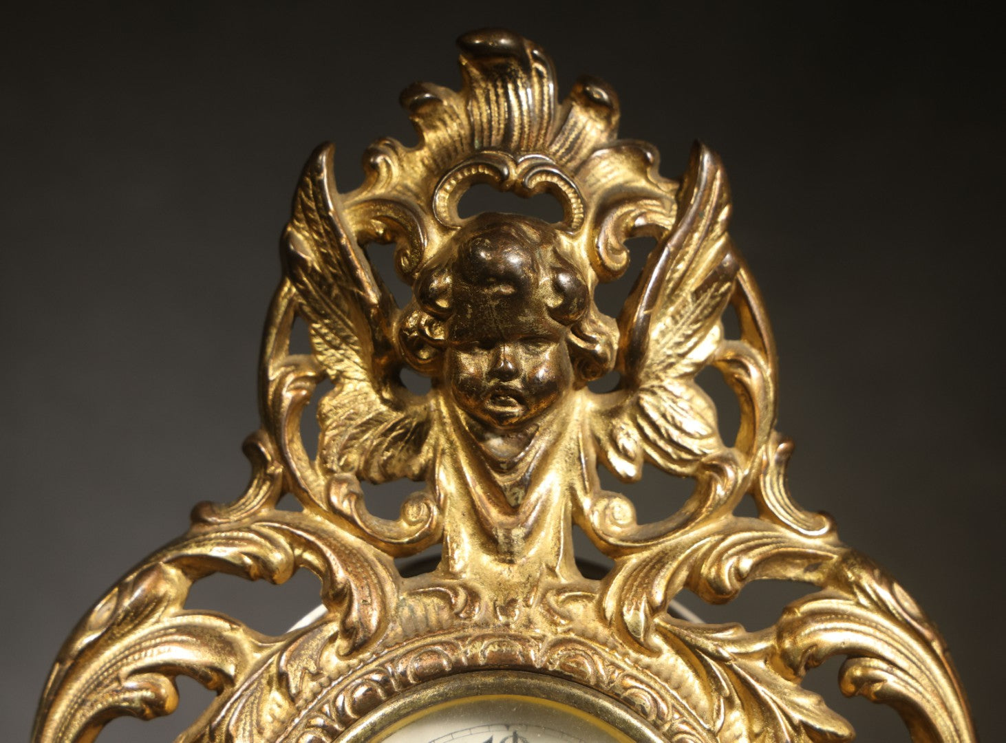 Antique Cast Brass Rococo Revival Style Mantel Clock with Winged Cherub, Grotesque Masks, and Scrolling Foliate Design, Signed A.F., Patented 1902-1908, Made in U.S.A.