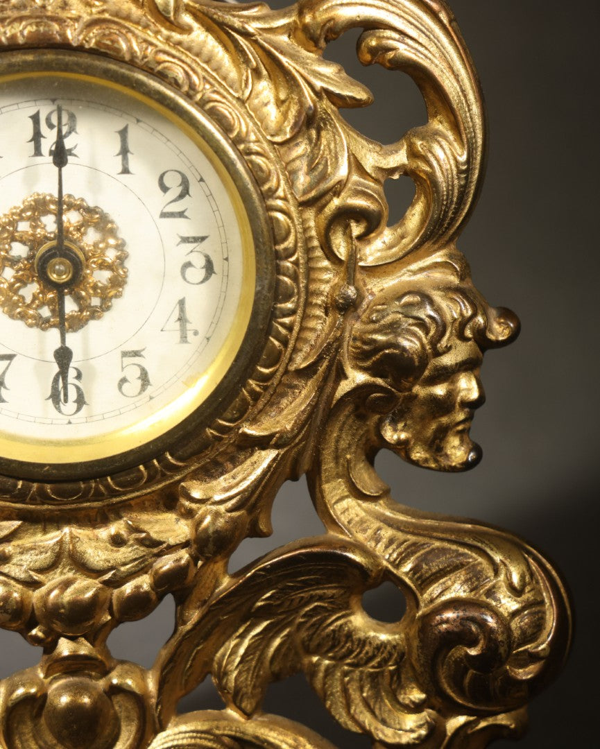 Antique Cast Brass Rococo Revival Style Mantel Clock with Winged Cherub, Grotesque Masks, and Scrolling Foliate Design, Signed A.F., Patented 1902-1908, Made in U.S.A.
