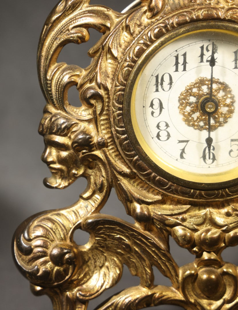 Antique Cast Brass Rococo Revival Style Mantel Clock with Winged Cherub, Grotesque Masks, and Scrolling Foliate Design, Signed A.F., Patented 1902-1908, Made in U.S.A.